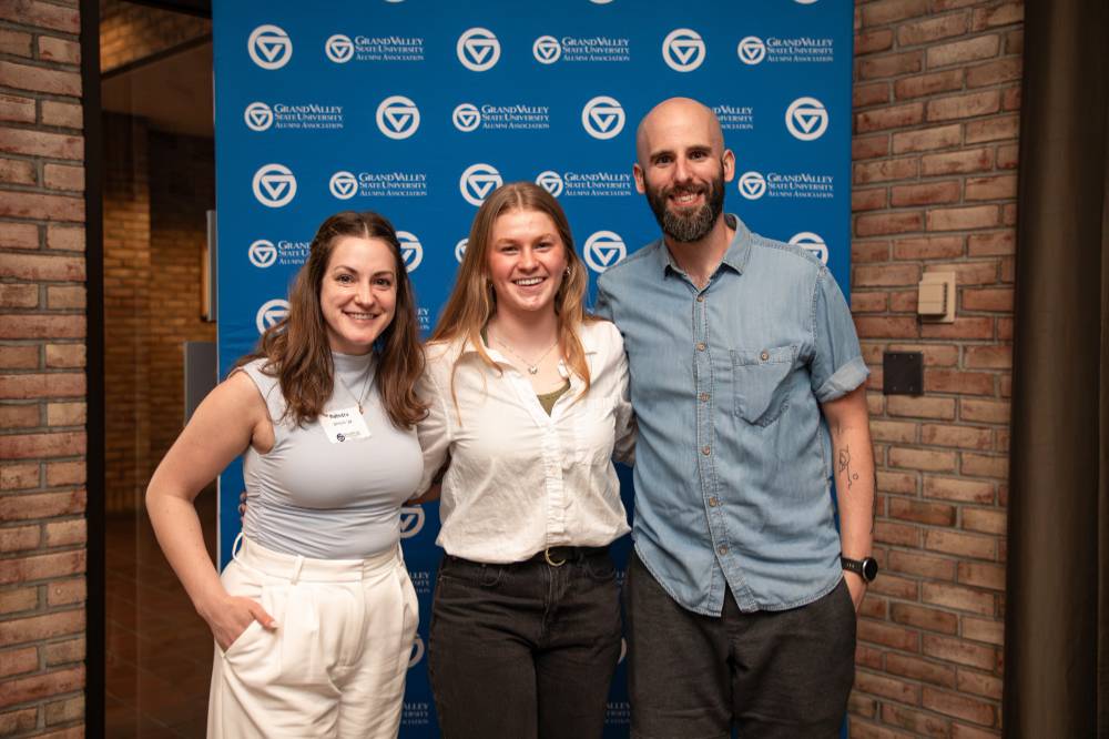 Three alums posing for a photo at the event.